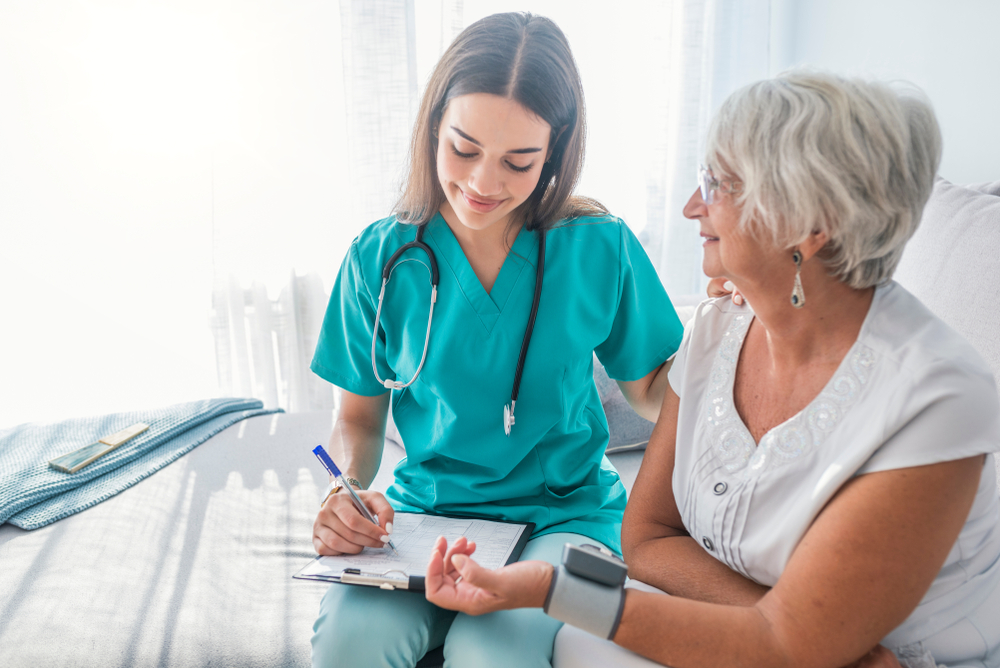 Nurse filling out paperwork while talking with a nurse