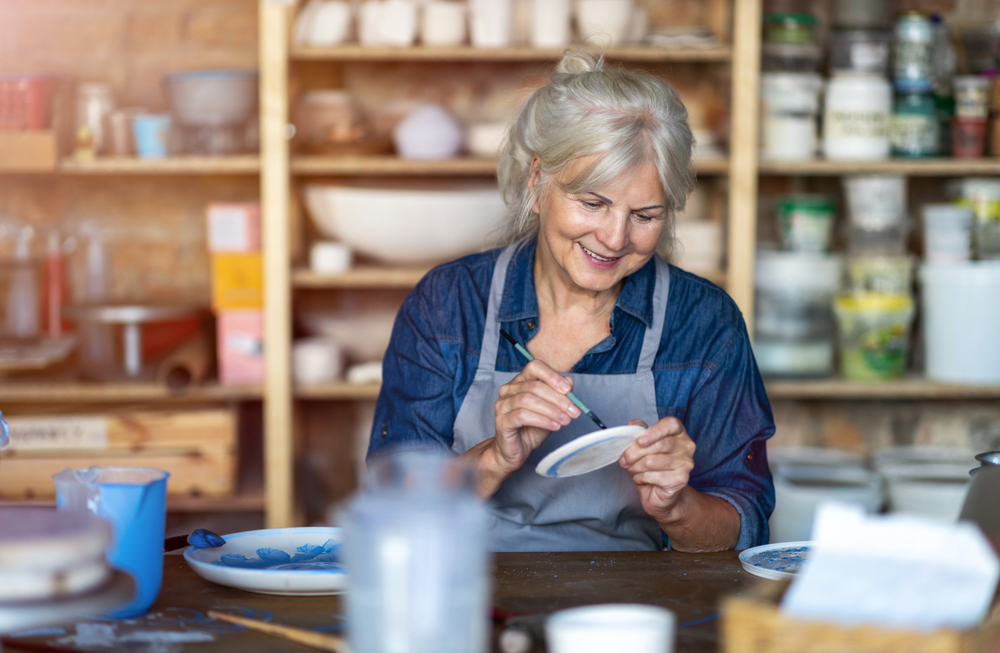 Senior woman painting pottery