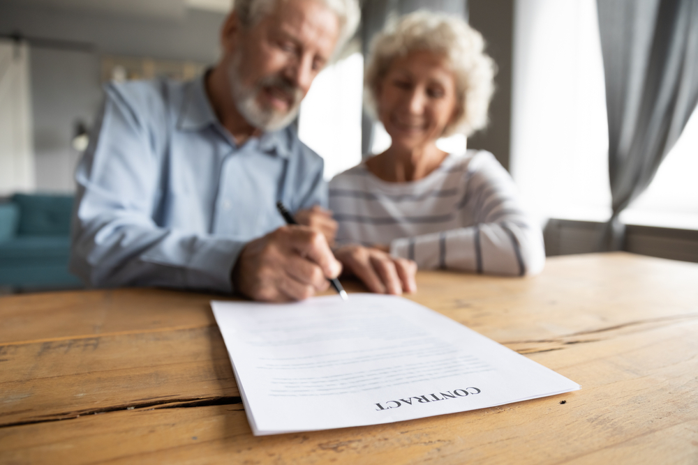 Senior couple signing a contract