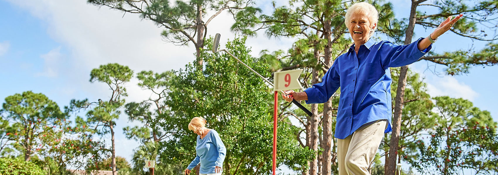 A senior woman celebrating her golf shot while playing on the golf course at her Delray Beach retirement community