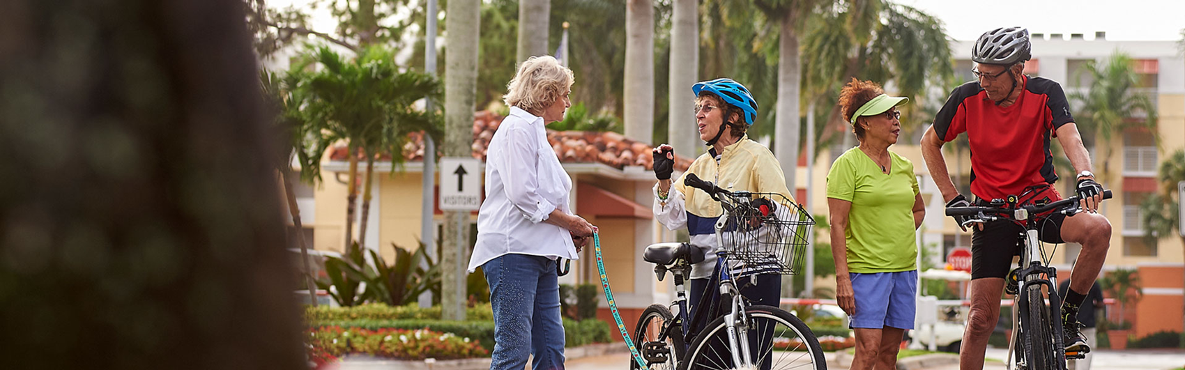 An elderly couple on bikes stopped to speak to two elderly women on a walk